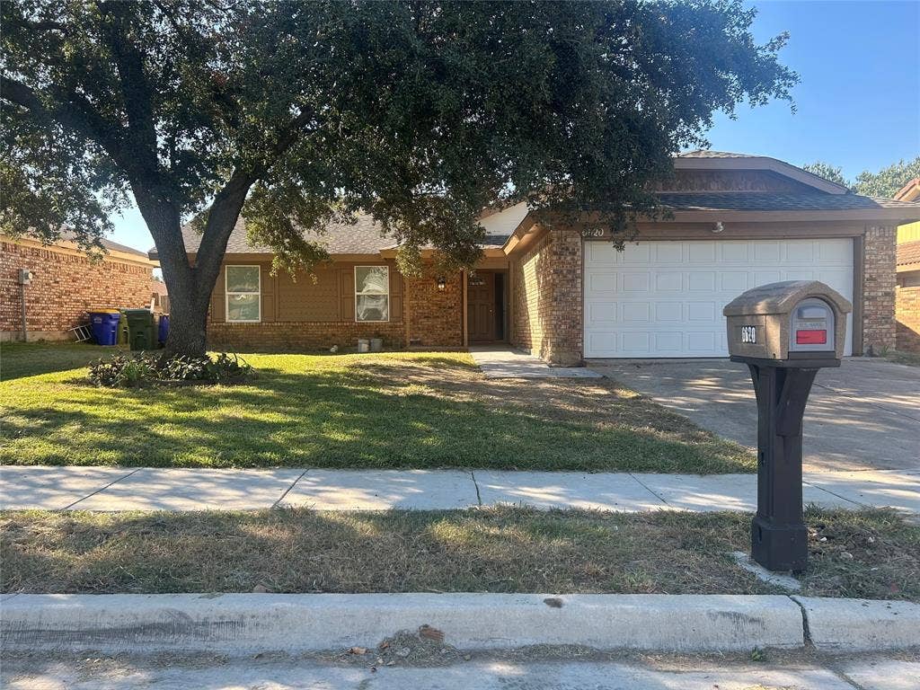 6620 Moss Lane, Watauga, TX 76148 Brick and siding exterior featuring an attached two-car garage with a white sectional door