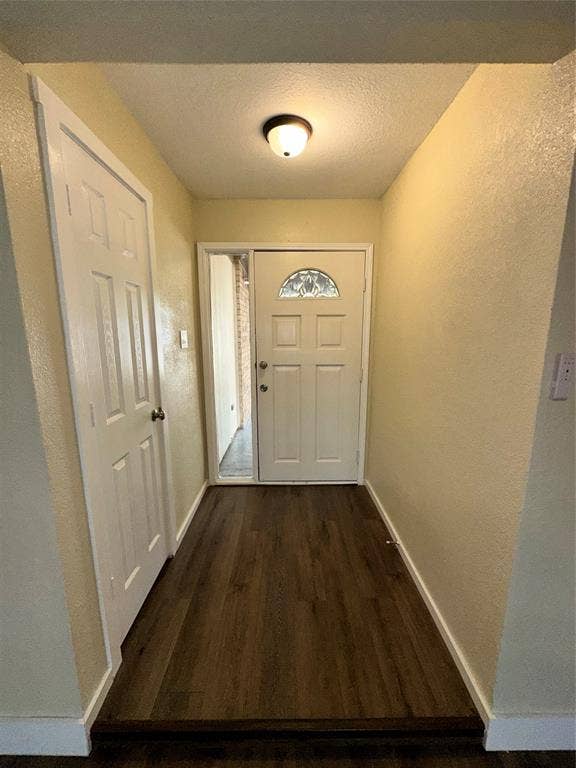 6620 Moss Lane, Watauga, TX 76148 Entryway featuring wood-finish flooring, white trim, and a paneled door with an arched decorative glass insert