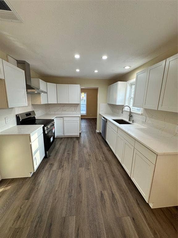 6620 Moss Lane, Watauga, TX 76148 Modern kitchen featuring white cabinetry, light-toned countertops, stainless steel appliances, wood-finish flooring, and recessed lighting