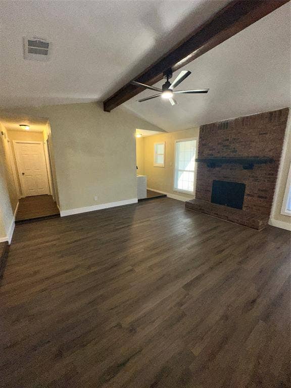 6620 Moss Lane, Watauga, TX 76148 Spacious living area featuring wood-finish flooring, a vaulted ceiling with exposed beams, and a modern ceiling fan