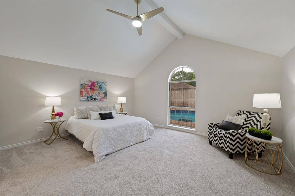 4420 Barwyn Lane, Plano, TX 75093 Spacious room featuring vaulted ceilings with an exposed beam, a ceiling fan, a large arched window, and light-toned carpeting