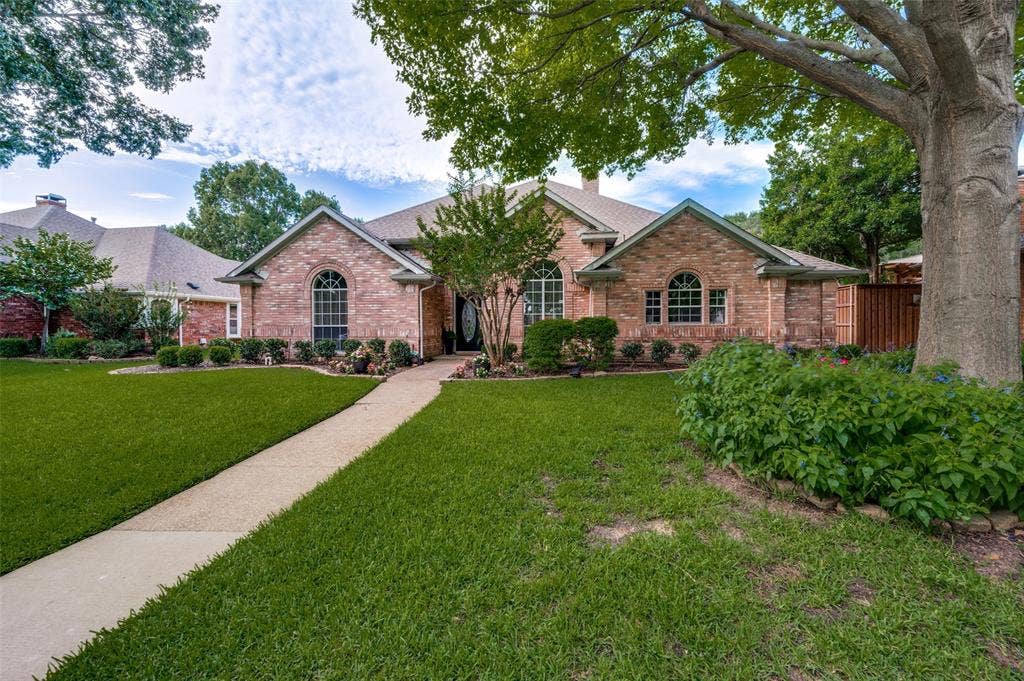 4420 Barwyn Lane, Plano, TX 75093 Established trees and landscaping frame this front entry with arched windows, and a concrete pathway