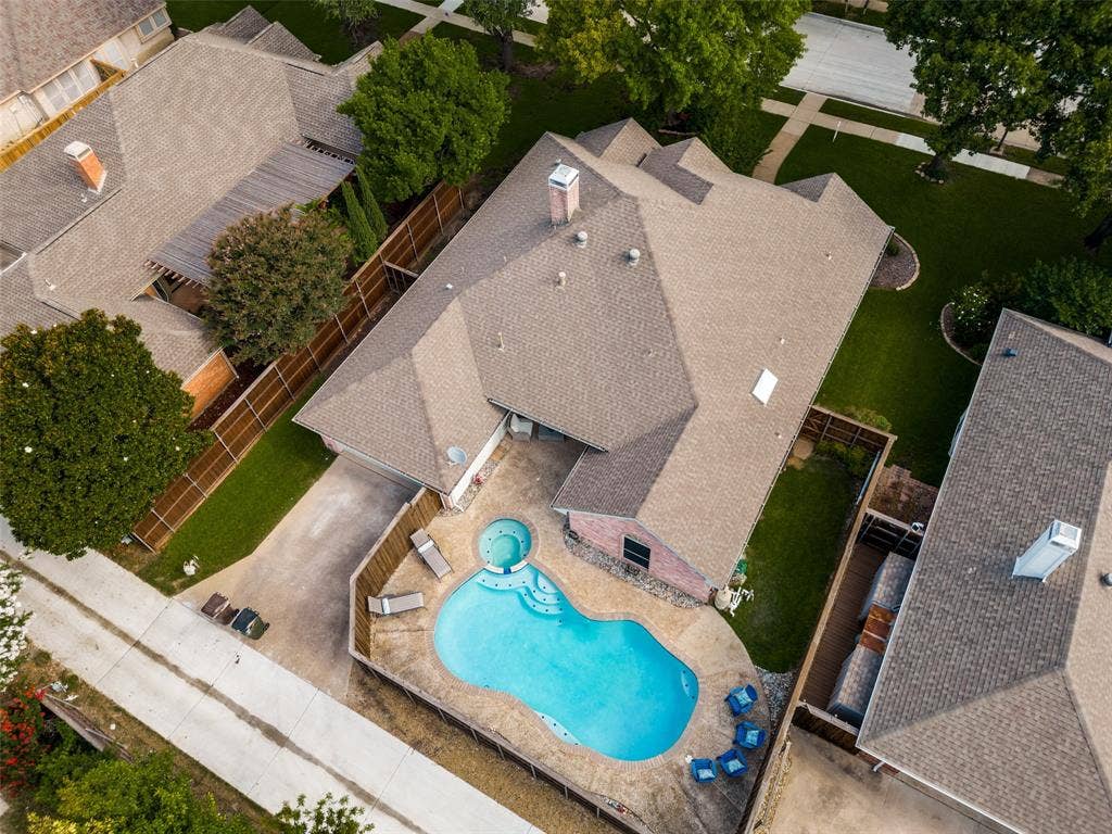 4420 Barwyn Lane, Plano, TX 75093 Residential property featuring a freeform swimming pool with integrated spa, a concrete pool deck, and a fenced backyard
