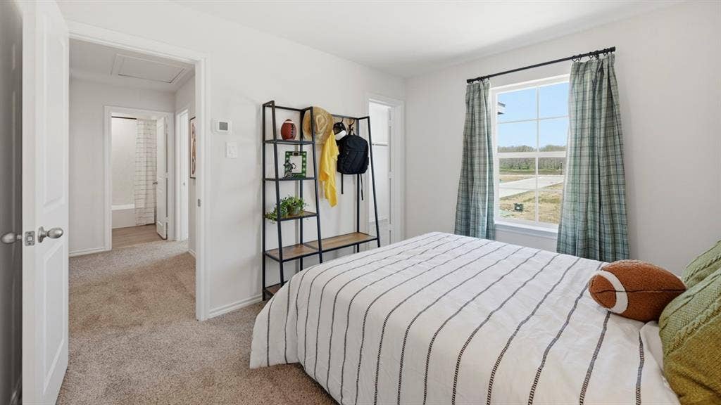 1957 Freeman Street, Tyler, TX 75704 Carpeted bedroom featuring a large window with exterior views, white walls, and a built-in wall shelf with wood-finish shelving