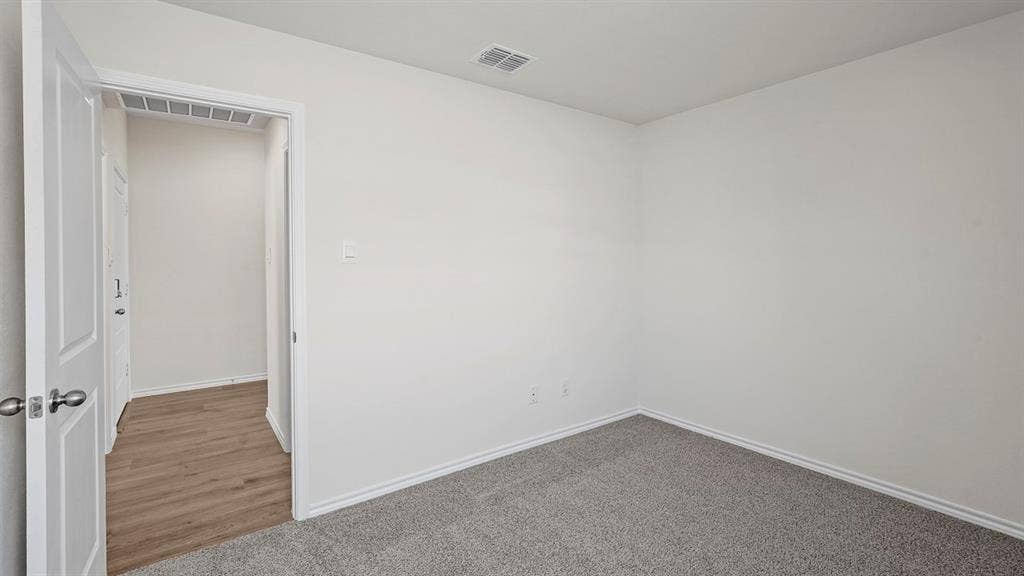 Interior room with light gray carpeting, white walls, and white baseboards