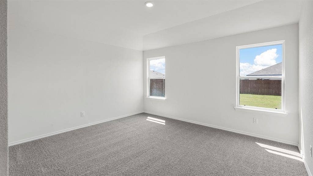 Spacious room featuring neutral paint, gray carpeting, dual windows, and recessed lighting