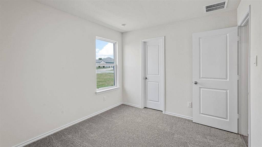 Bright room with neutral wall paint and gray carpet flooring