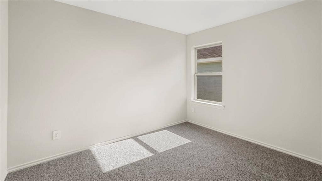 1969 Freeman Street, Tyler, TX 75702 Neutral-toned room featuring a single window with white trim, light gray wall paint, and plush gray carpeting