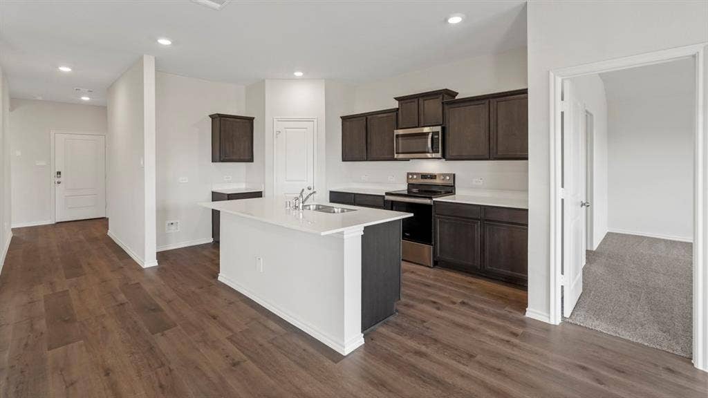 1969 Freeman Street, Tyler, TX 75702 Modern kitchen featuring a central island, dark wood-finish cabinetry, white countertops, stainless steel appliances, and wood-finish flooring