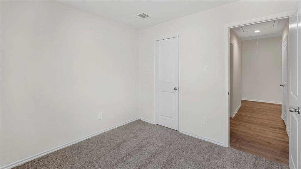 1969 Freeman Street, Tyler, TX 75702 Interior space featuring light gray carpeting, white baseboards, and a solid white interior door with a silver knob