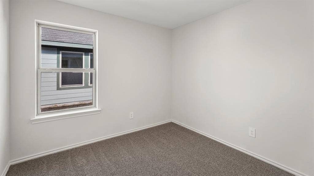1969 Freeman Street, Tyler, TX 75702 Room featuring light gray walls, gray carpet flooring, white baseboards, and a single-pane window with white trim
