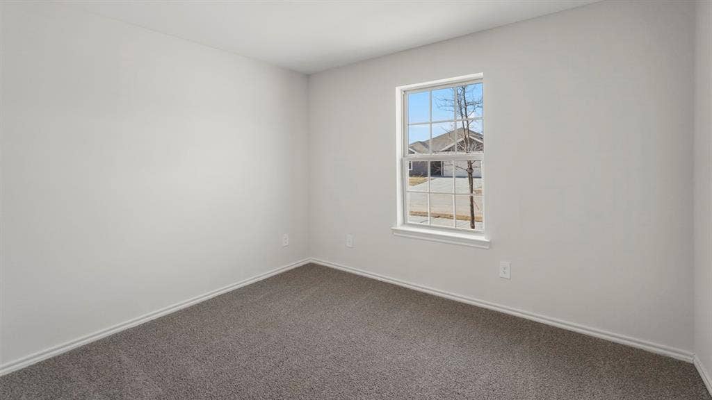 1969 Freeman Street, Tyler, TX 75702 Bright interior room featuring a grid-pattern window, light gray walls, dark gray carpet, and white baseboards