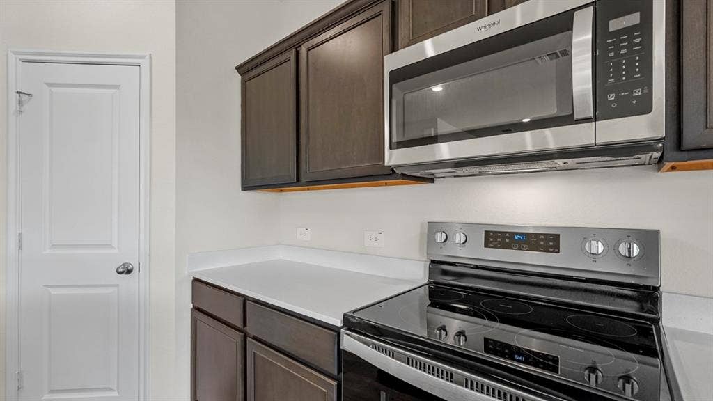 1969 Freeman Street, Tyler, TX 75702 Kitchen featuring stainless steel appliances, dark wood cabinetry, and light countertops