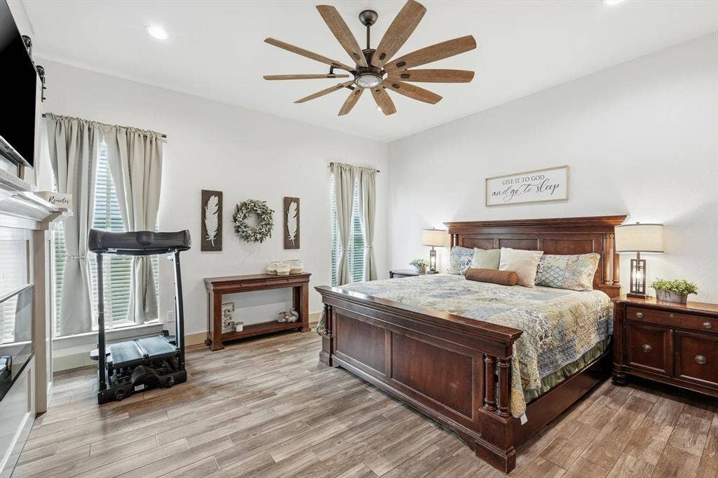 Spacious interior featuring wood-finish flooring, recessed lighting, and a multi-blade ceiling fan