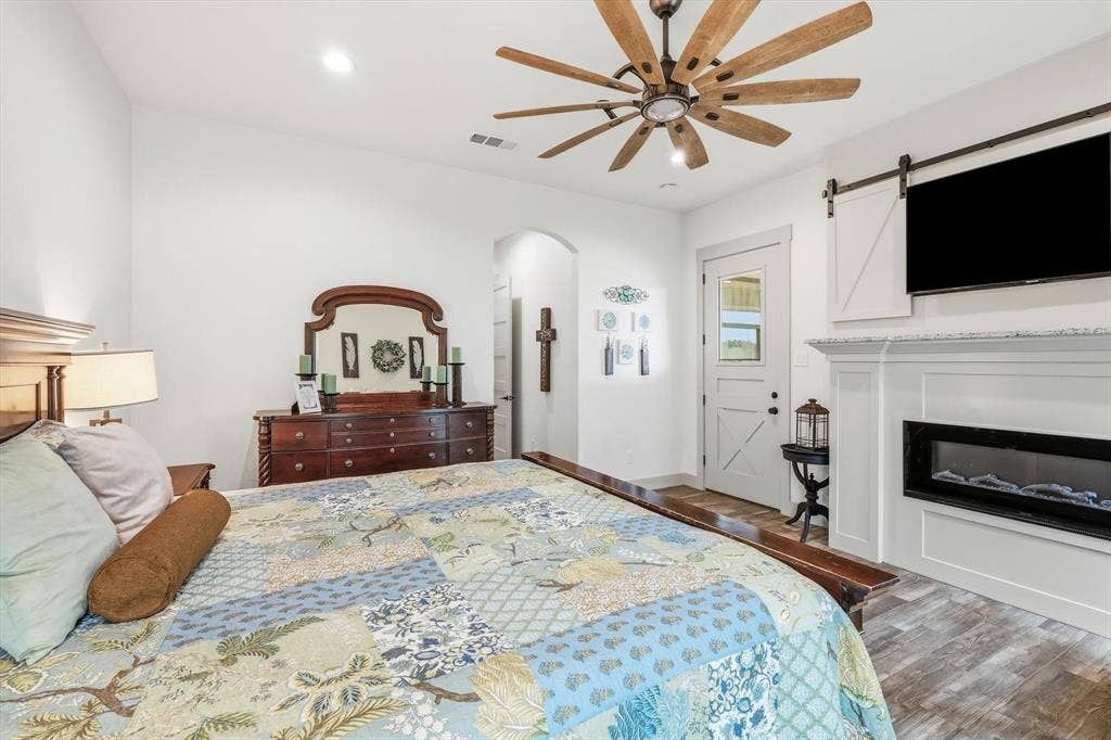 Bright room featuring wood-finish flooring and a white fireplace with a dark insert