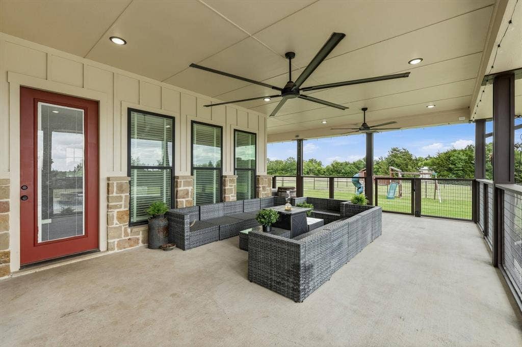 Expansive covered patio featuring a concrete floor, recessed lighting, and two ceiling fans