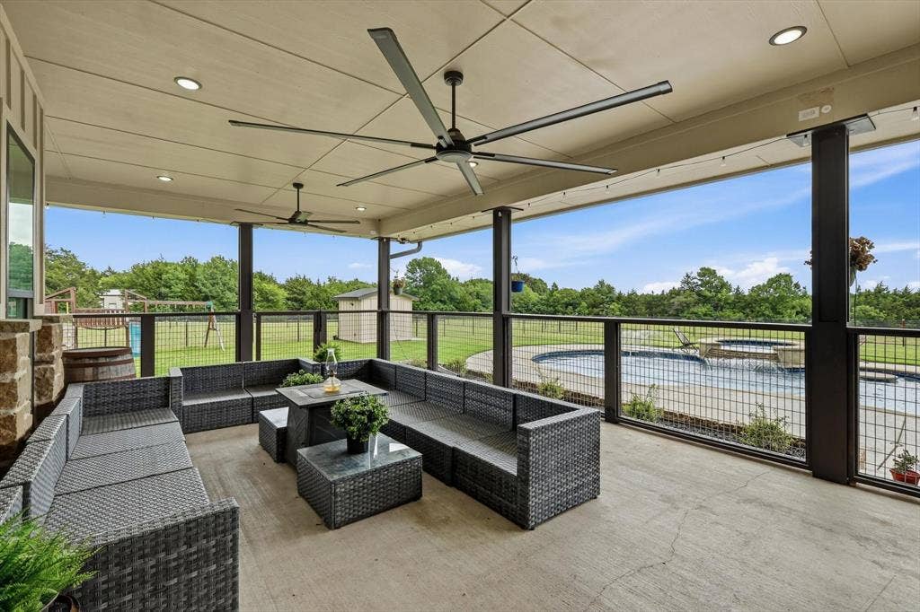 Covered patio with concrete flooring, stone column, recessed lighting, and ceiling fans