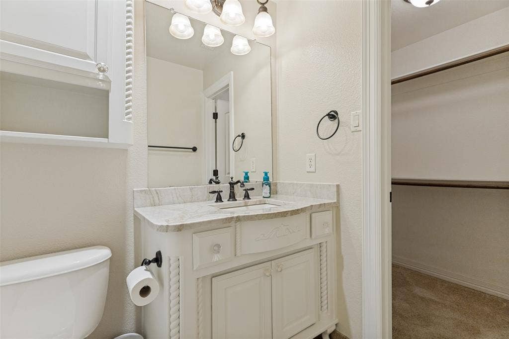 Bathroom vanity with a light-toned countertop, a built-in sink, and dark-finished fixtures