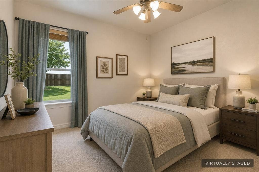 Carpeted bedroom with a ceiling fan, window with backyard scenery, and light-colored walls