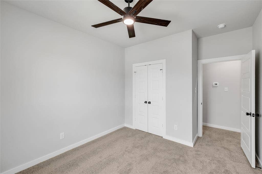 6600-6602 Florence Drive, Midlothian, TX 76065 Neutral-toned room featuring a ceiling fan with light, light gray carpeting, and white trim