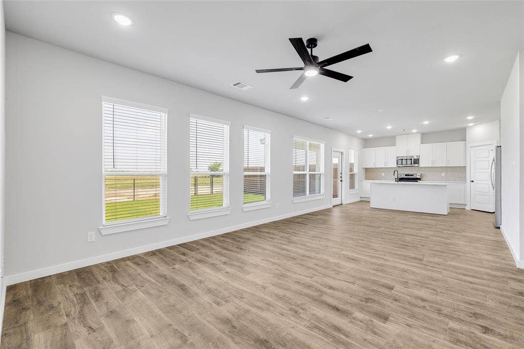 6600-6602 Florence Drive, Midlothian, TX 76065 Expansive open-concept living space featuring wood-finish flooring, recessed lighting, and a contemporary ceiling fan