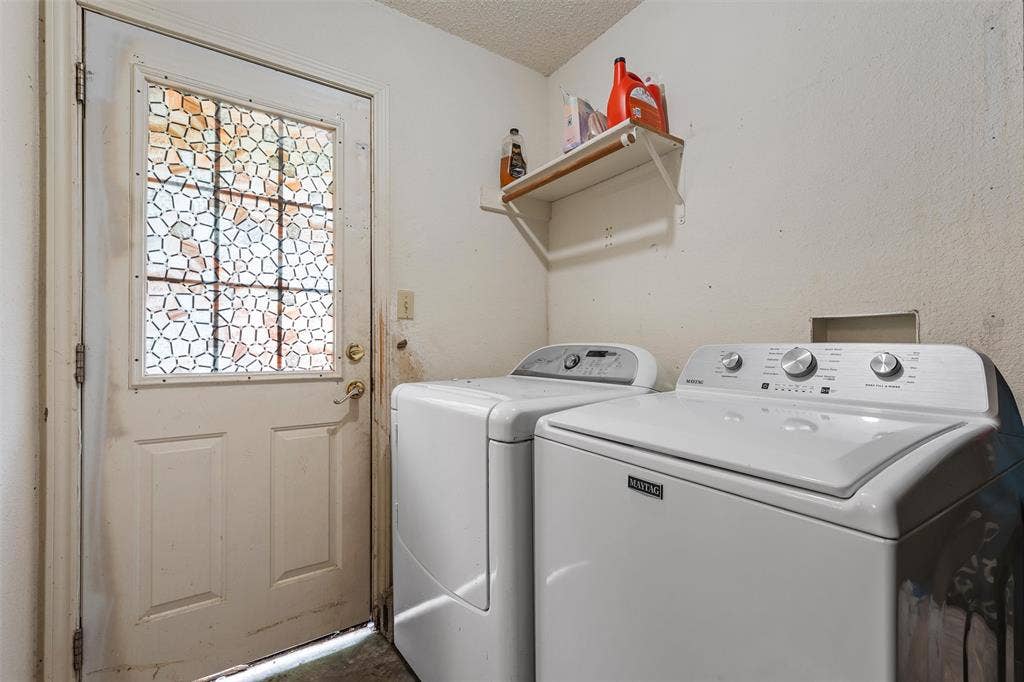 1307 Luanne, Bellmead, TX 76705 Laundry area featuring a utility door with patterned glass, white painted walls, and a wall-mounted shelf