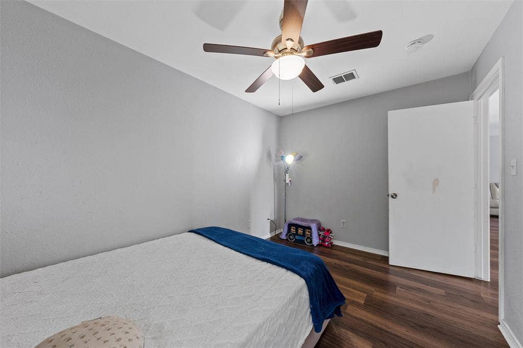 1307 Luanne, Bellmead, TX 76705 Bedroom featuring wood-finish flooring, a ceiling fan with integrated lighting, textured walls, and a white interior door