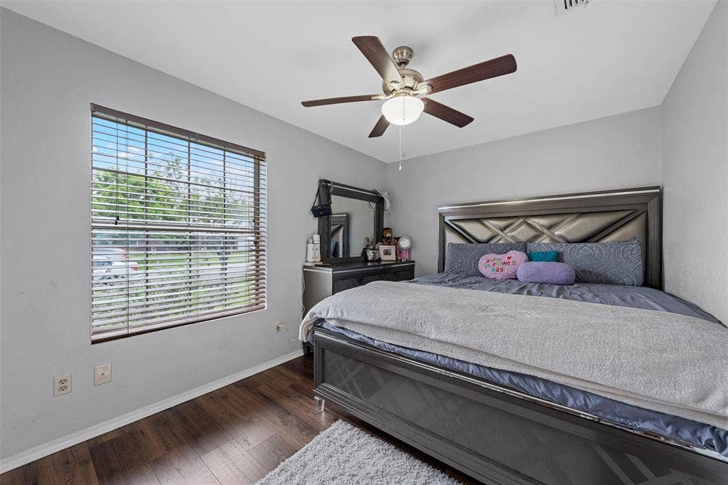 1307 Luanne, Bellmead, TX 76705 Bedroom with wood-finish flooring, a ceiling fan with integrated lighting, and a window featuring horizontal blinds