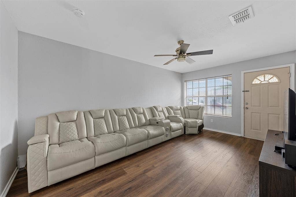 1307 Luanne, Bellmead, TX 76705 Spacious living area featuring wood-finish flooring, light gray walls, a ceiling fan, and ample natural light from a front-facing window