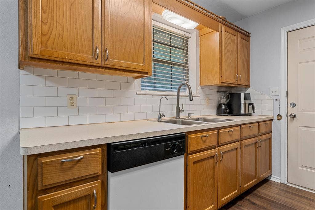1307 Luanne, Bellmead, TX 76705 Kitchen featuring wood cabinetry, white subway tile backsplash, and a double basin stainless steel sink with a gooseneck faucet