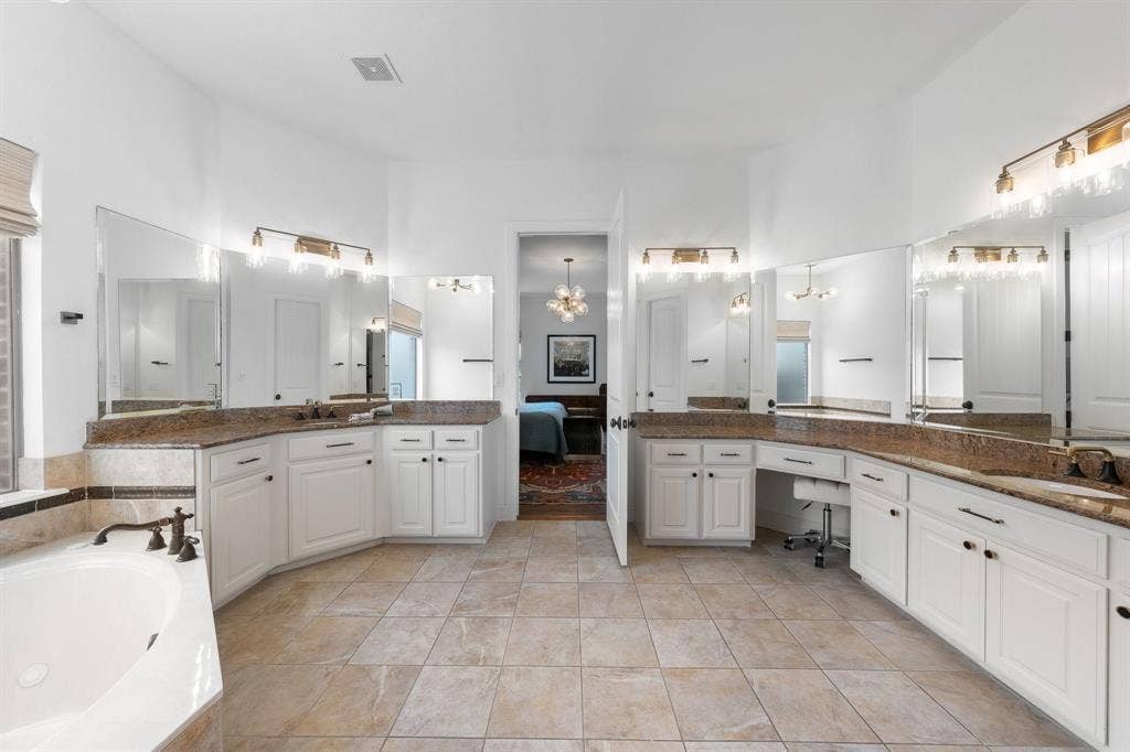 Spa like bathroom with his and her vanities and tons of cabinet storage.