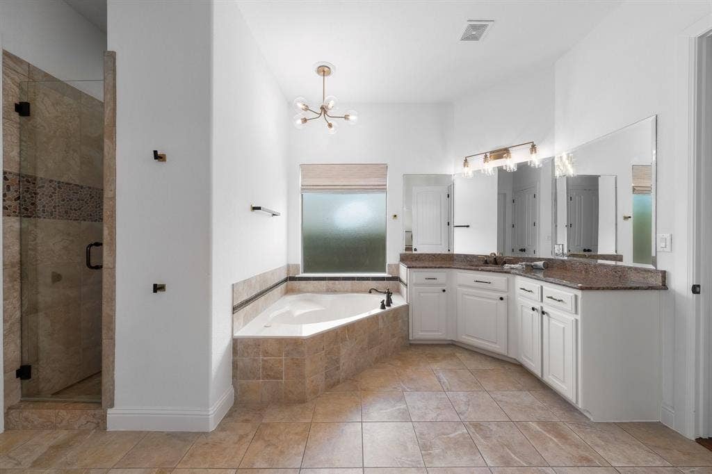 Primary bathroom with soaker tub and his and her vanities