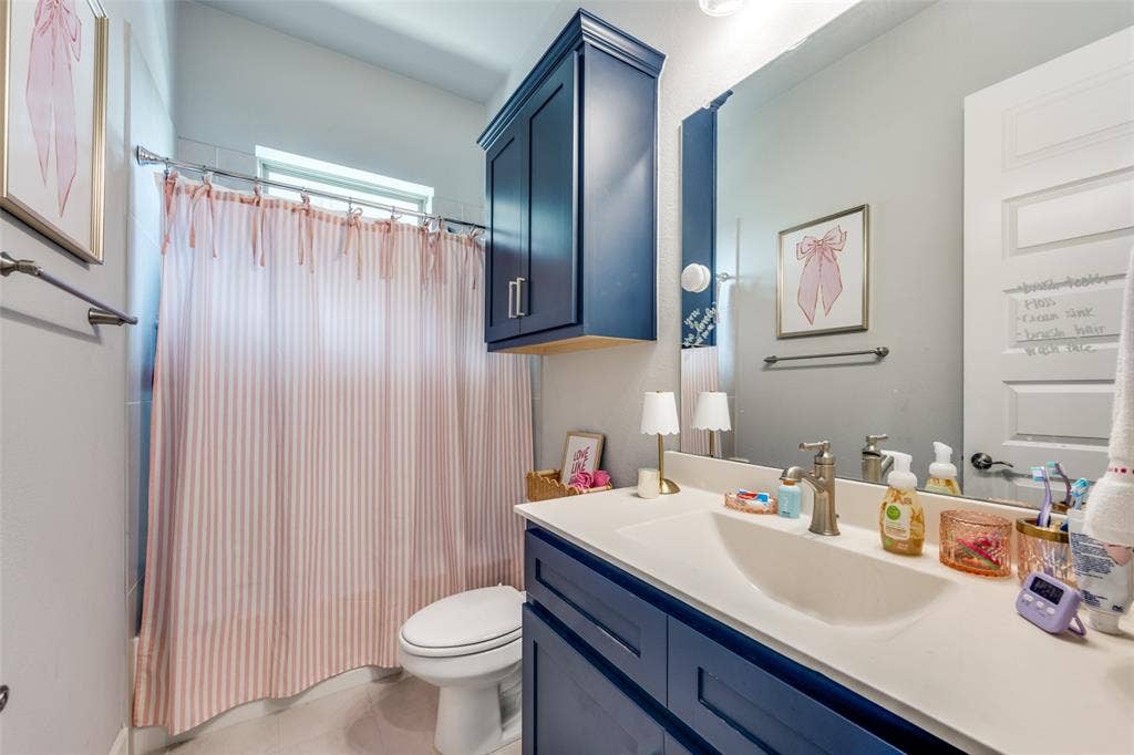 2703 Trinity Ridge Street, Mansfield, TX 76063 Bathroom featuring a white integrated sink, white countertop, and navy blue cabinetry