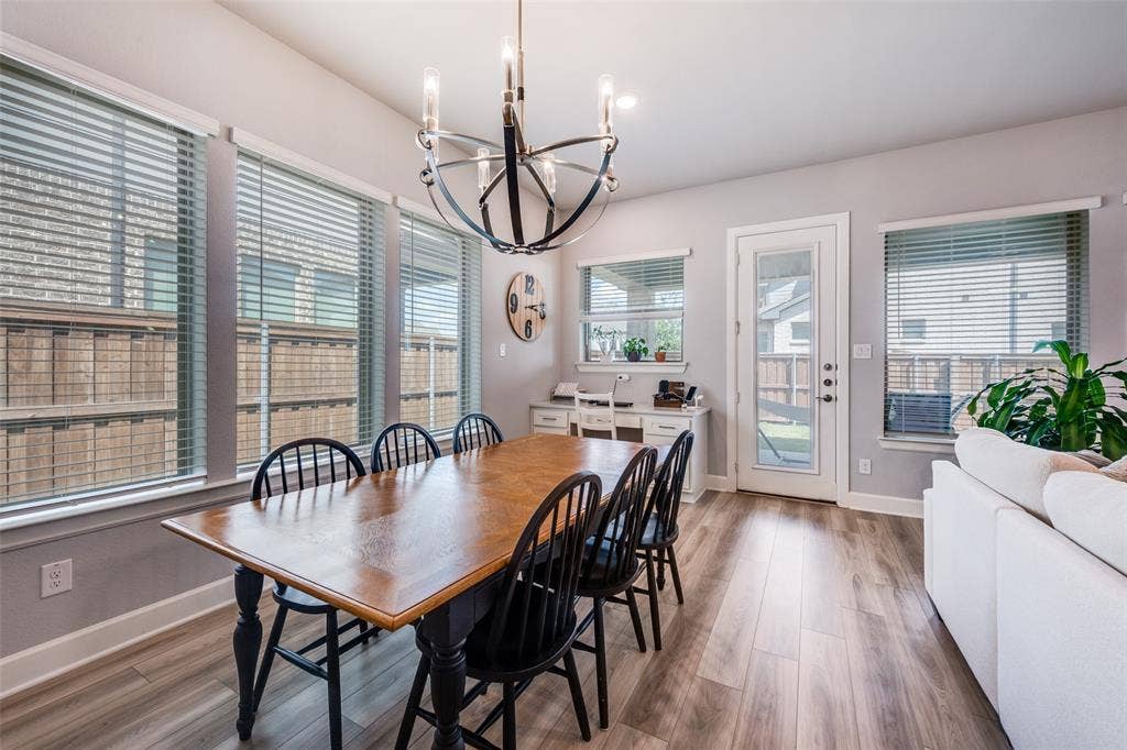 2703 Trinity Ridge Street, Mansfield, TX 76063 Open-concept room featuring wood-finish flooring, multiple windows with blinds, and a glass-paneled exterior door