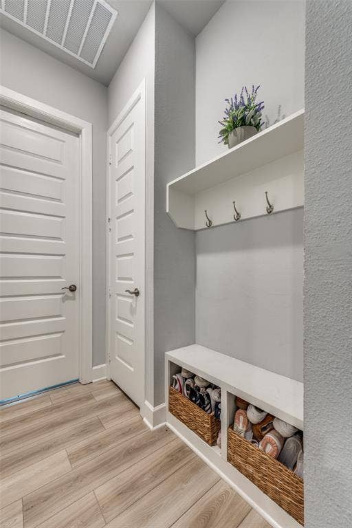 2703 Trinity Ridge Street, Mansfield, TX 76063 Entryway featuring a built-in bench with integrated shelving, overhead shelf with coat hooks, light wood-finish flooring, and two paneled doors