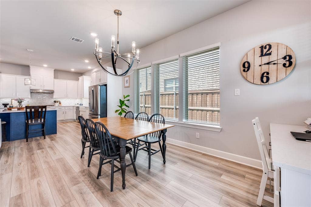 2703 Trinity Ridge Street, Mansfield, TX 76063 Open concept dining area featuring wood-finish flooring, a contemporary chandelier, and a bright kitchen beyond