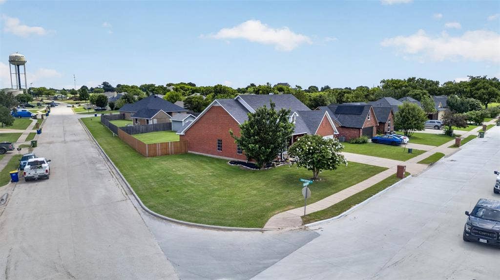 Corner lot property featuring a brick exterior and an attached garage