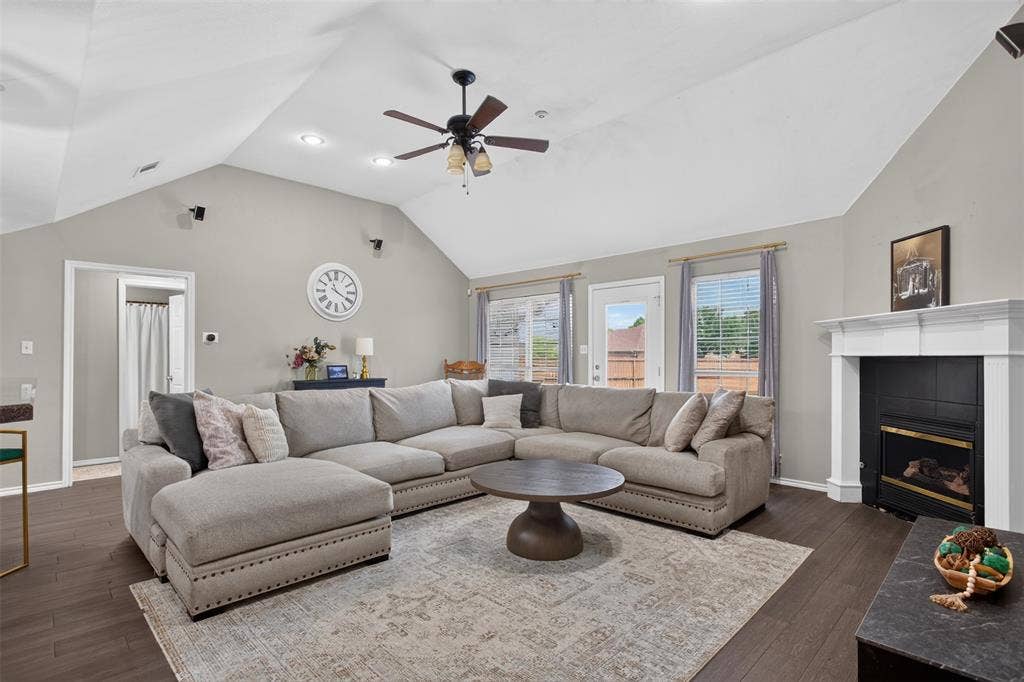 Spacious living area featuring vaulted ceilings, dark wood-finish flooring, and recessed lighting