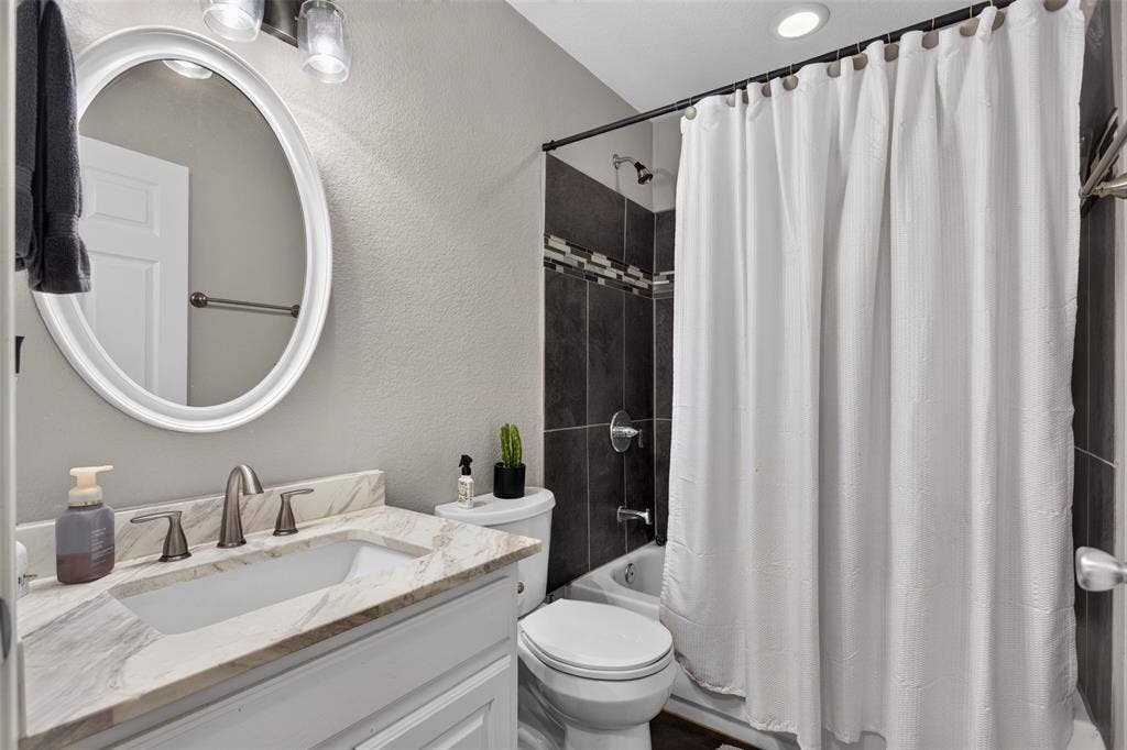 Bathroom vanity featuring a rectangular undermount sink, dual-handle faucet, and patterned countertop