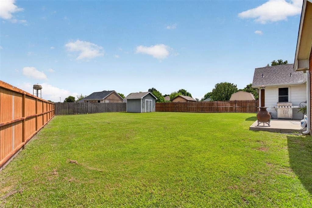 Expansive green lawn with a wood privacy fence