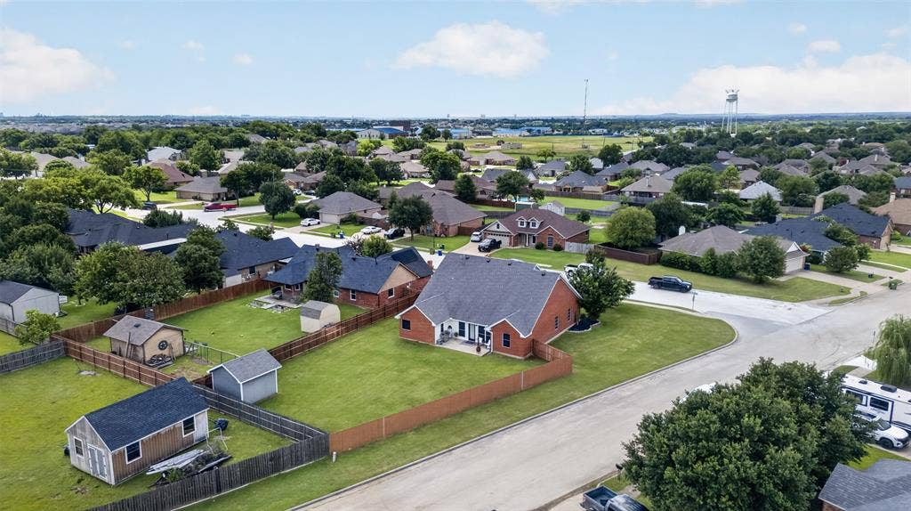 Expansive green lawns with mature trees, fenced backyards, and multiple outbuildings