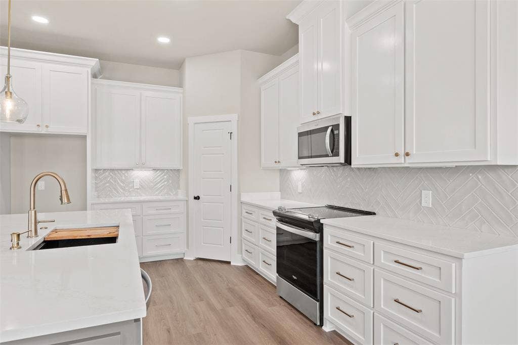 9824 Durango Trail, Waco, TX 76712 Kitchen featuring white shaker cabinetry, light wood-finish flooring, white countertops, and a herringbone tile backsplash
