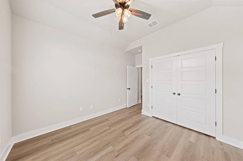 9824 Durango Trail, Waco, TX 76712 Spacious room featuring wood-finish flooring, white baseboards, and a modern ceiling fan with integrated lighting