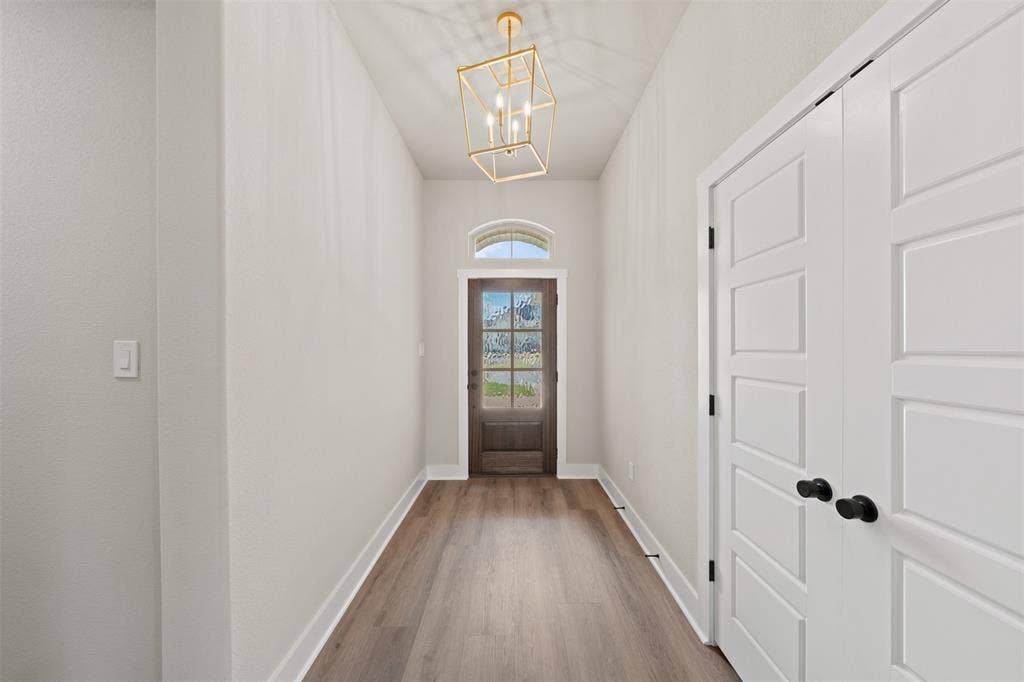 9824 Durango Trail, Waco, TX 76712 Entryway with wood-finish flooring, white baseboards, and light neutral wall finishes