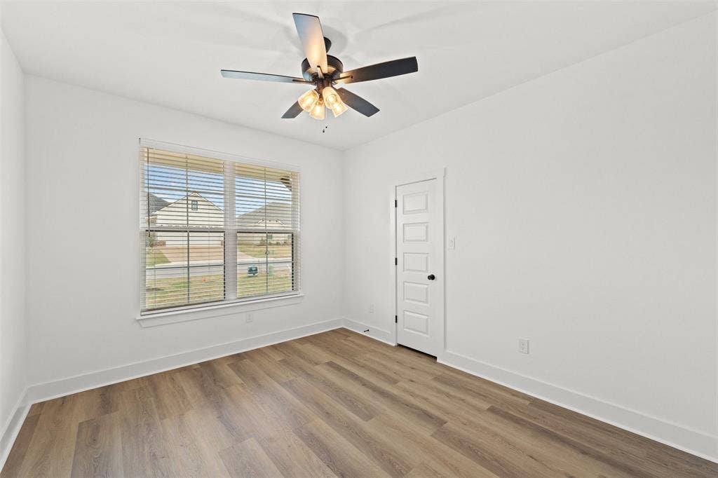 9820 Durango Trail, Waco, TX 76712 Bright room featuring a multi-light ceiling fan, a window with horizontal blinds, and wood-finish flooring