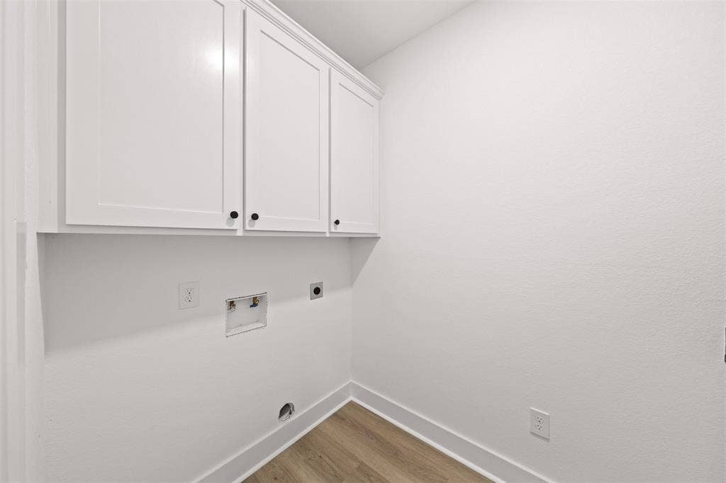 9820 Durango Trail, Waco, TX 76712 White shaker cabinetry with crown molding and matte black hardware, wood-finish flooring, and white baseboards