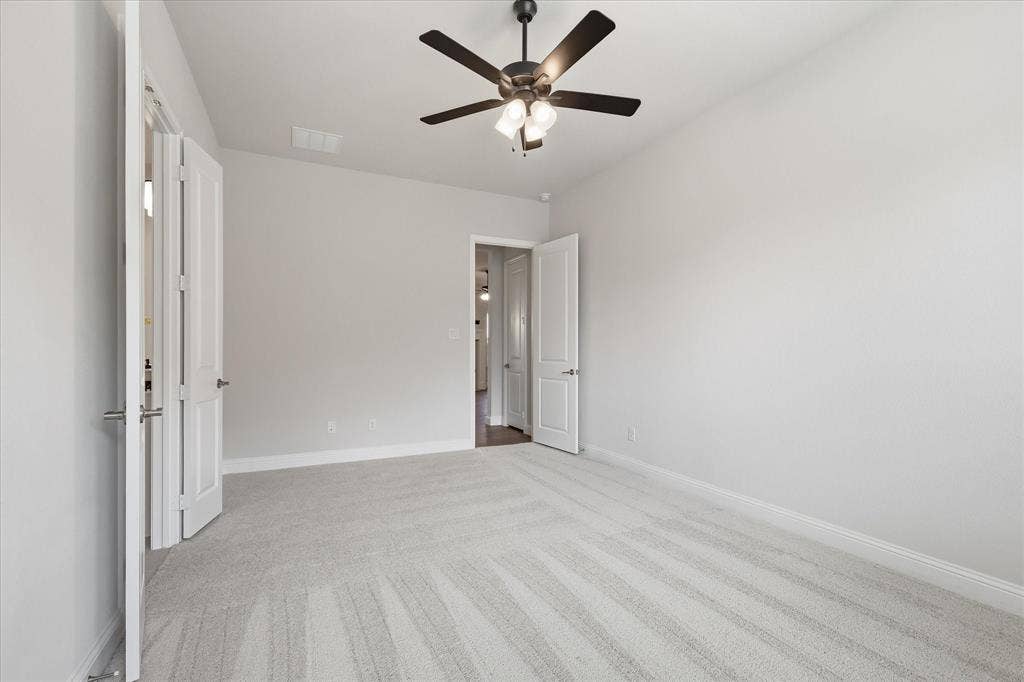 4017 Alpine Street, Midlothian, TX 76065 Spacious room featuring light-toned carpeting, a ceiling fan with integrated lighting, white baseboards, and neutral wall tones