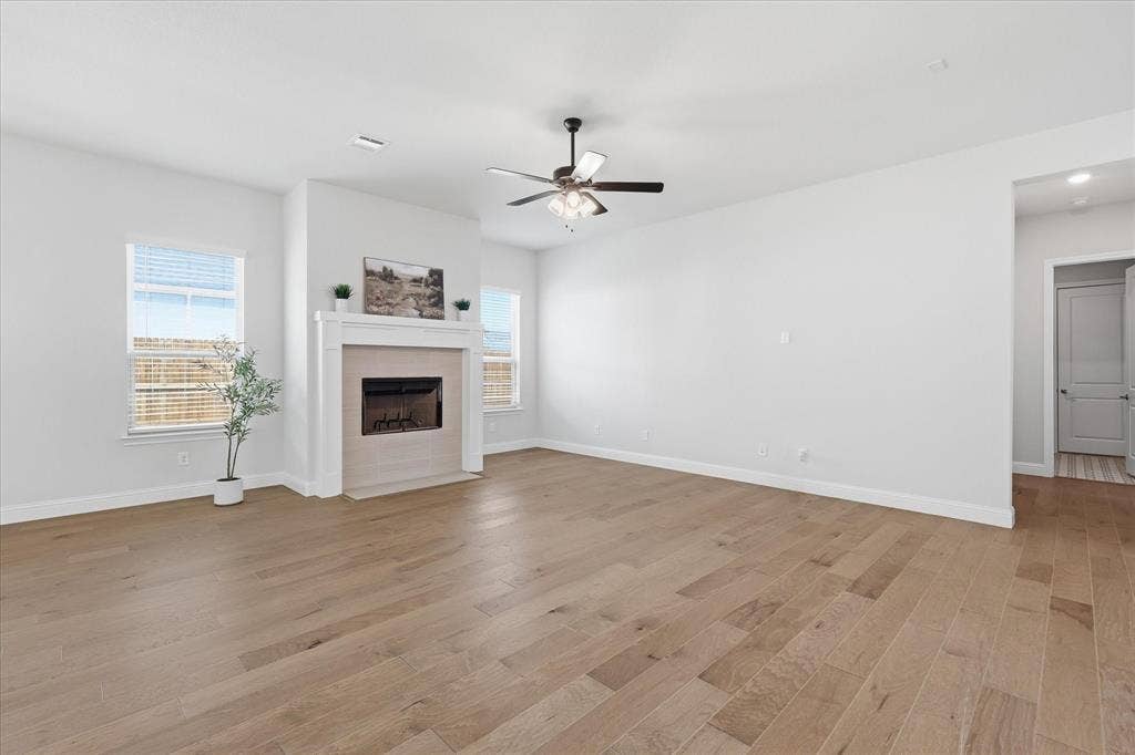 4017 Alpine Street, Midlothian, TX 76065 Spacious living area featuring wood-finish flooring, a ceiling fan, and a fireplace with a mantel