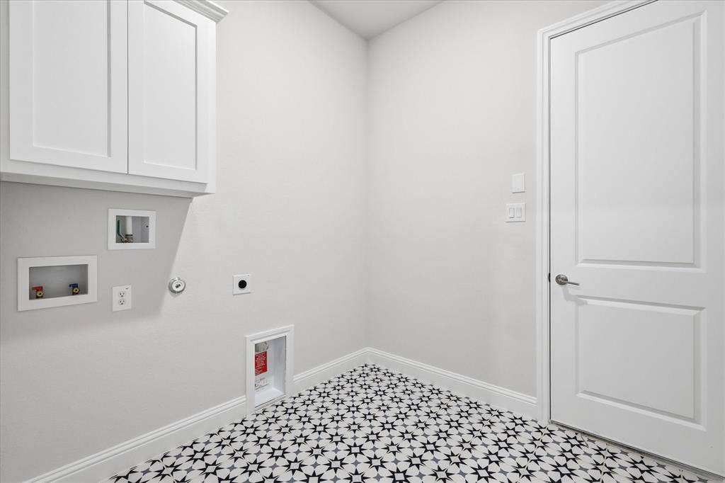 4017 Alpine Street, Midlothian, TX 76065 Laundry room featuring patterned floor tile, white shaker-style cabinetry, and crisp white baseboards