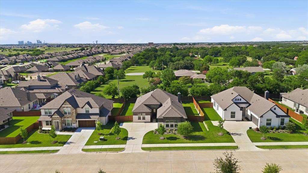 4017 Alpine Street, Midlothian, TX 76065 Residential street featuring three distinct homes with attached garages, concrete driveways, and manicured lawns